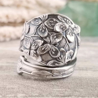 Antique silver embossed floral wide ring standing on wood table