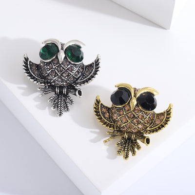 Front view of round owl with oversized faceted eyes and textured feather details