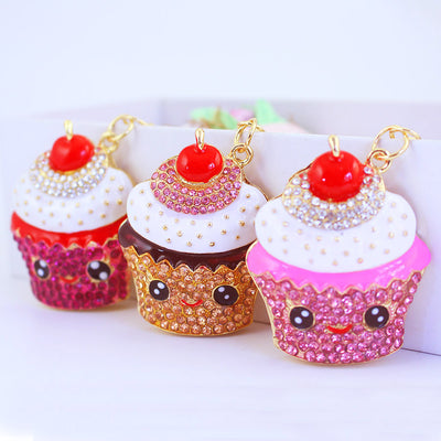 Three smiling cupcake keychains in pink, peach, and magenta are displayed together.