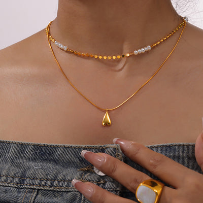 Layered gold heart and pearl necklace worn on collarbone