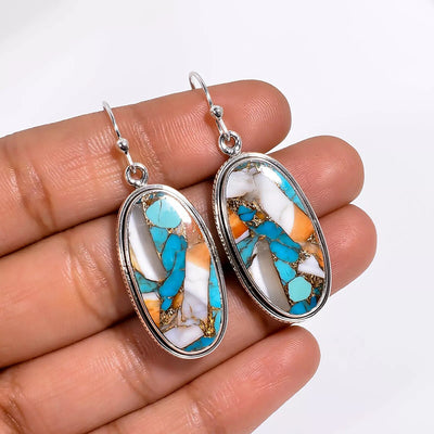 Silver oval turquoise mosaic drop earrings held in palm