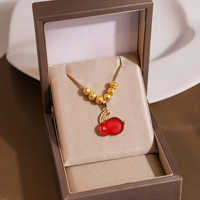 Gold red rabbit pendant necklace displayed in open beige jewelry box