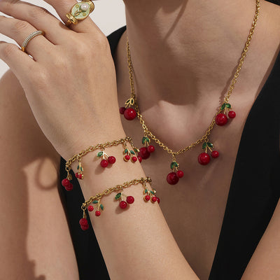 Coordinated set view of red cherry charm necklace and bracelet in main image 1.