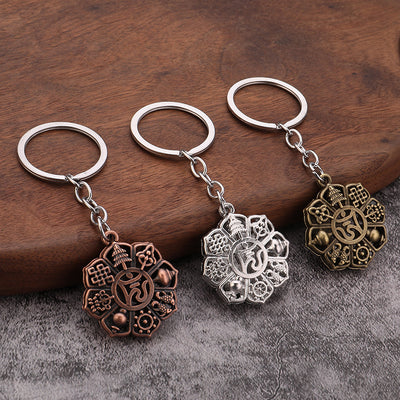 Three round auspicious-symbol keychains on wood