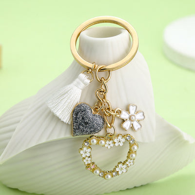 Image 1 showing a white vase with a keychain and some charms.