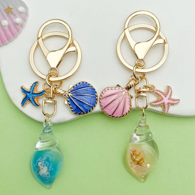 Image 1 showing two key chains with sea shells and seashells.