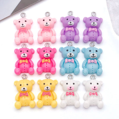 Multicolor bow and butterfly charms arranged on a light background