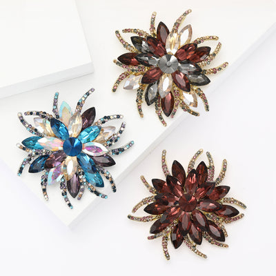 Front view showing the antique gold layered flower brooch with faceted crystal petals