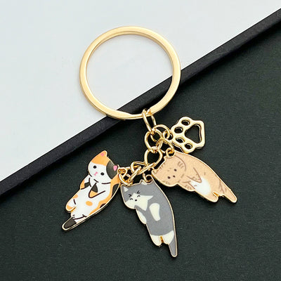 Front product photo of three-cat calico orange and blue enamel paw print charm keychain showing the pictured design arra