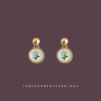 Mint enamel daisy disc drops on solid mauve product backdrop