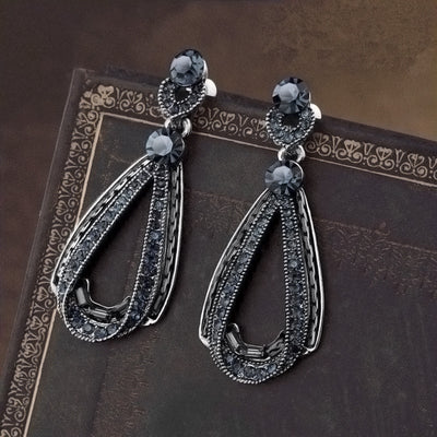 Pair antique silver dark blue teardrop drop stud earrings on dark patterned book
