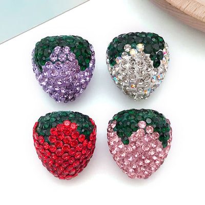Multicolor strawberry charms arranged on a light background