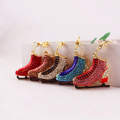 Five rhinestone ice skate accessories displayed together in assorted colors.