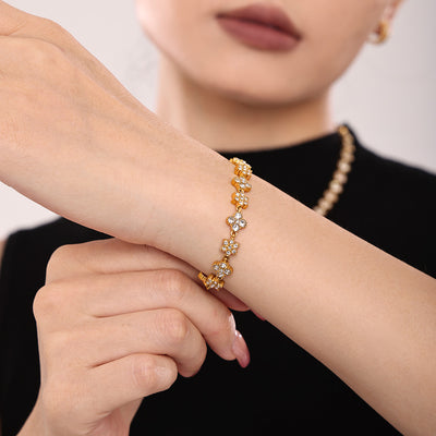 Model wearing gold four-leaf clover zircon bracelet on wrist