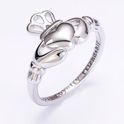 Silver Claddagh ring heart hands crown side angle white background