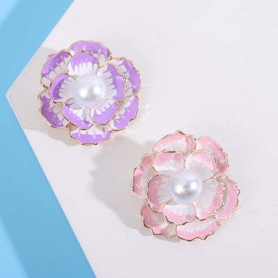 Two colorways of purple and pink pearl camellia brooches shown side by side.