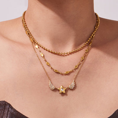 Neckline view of crystal winged star pendant necklaces in main image 1.