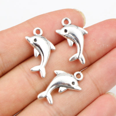 Overview of curved leaping-dolphin silhouettes with small top loops and silver-tone surfaces