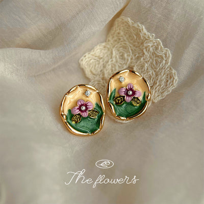 Gold enamel pink flower organic oval studs on cream lace fabric
