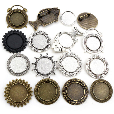Front overview of assorted round brooch tray settings in mixed metal tones arranged on a light background