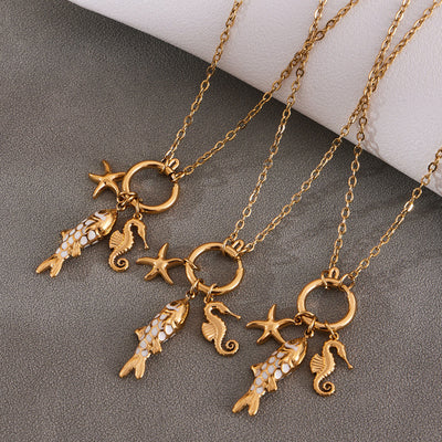 Three gold fish seahorse star charm necklaces close-up