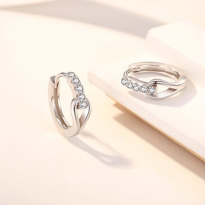 White gold twist huggie hoops pair on white block display