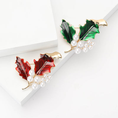 Front view of the enamel holly leaf brooch with clustered pearl berries on a white background