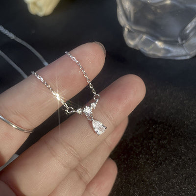 Product view showing a clear teardrop stone hanging below a small clustered centerpiece