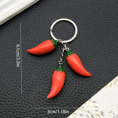 Front product photo of red three-dimensional chili pepper keychain with metal ring showing the pictured design arrangeme