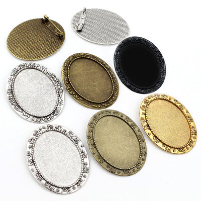Ornate Oval Cabochon Brooch and Pendant Bezel Settings, grouped overview on a plain background