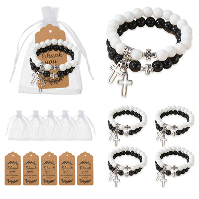 Black and white cross charm bracelets shown beside white organza bags and kraft thank-you tags.