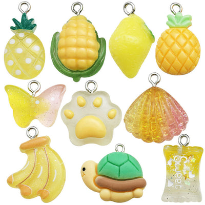 Yellow pineapple and shell charms arranged on a light background