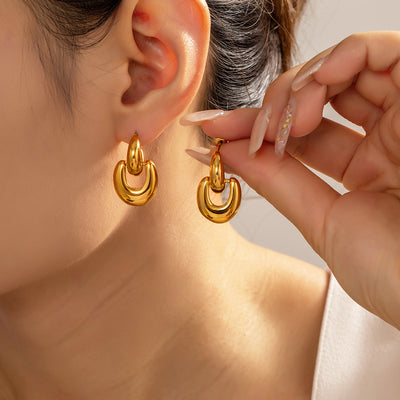 Model ear wearing gold geometric dual loop linked stud earring