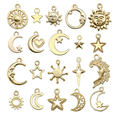Gold-tone moon and sun charms arranged on a light background