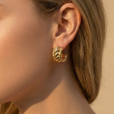 On-ear view of twisted link C hoop stud earrings in main image 1.