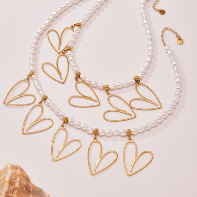 Two gold shell bead necklaces with five open heart pendants each
