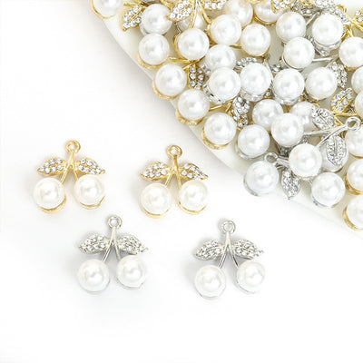 Assorted pearl cherry charms arranged beside a tray