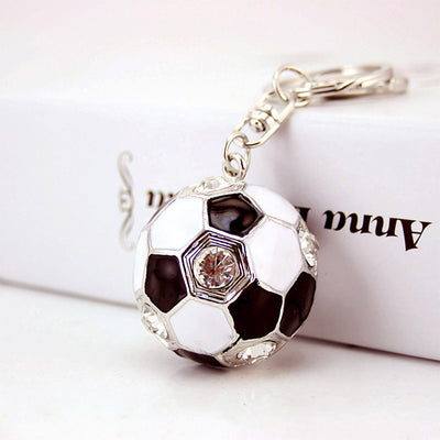 Close view of a black and white soccer ball keychain with clear faceted accents.