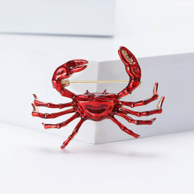 Front product view of the red enamel crab brooch on a light background