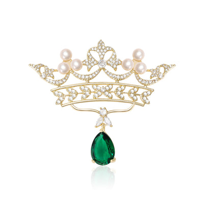 Front product view of the open gold-tone crown with pearls, clear crystals, and a green teardrop brooch