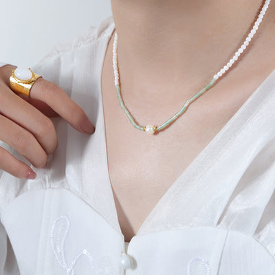 Model wearing mint tube bead pearl center necklace with white blouse