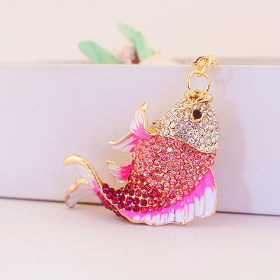 Front angled view of the fish charm covered with pink and clear rhinestones.
