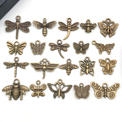 Gold-tone butterfly and bee charms arranged on a light background