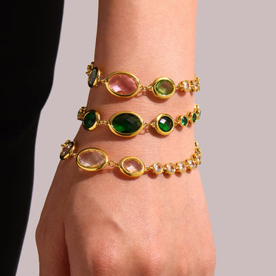 Three gold Czech glass oval bracelets stacked on wrist pink green clear