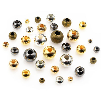 Smooth Round Metal Spacer Beads in Seven Sizes and Finishes assortment on a plain background