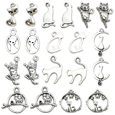 Antique silver cat and cat paw charms arranged on a light background