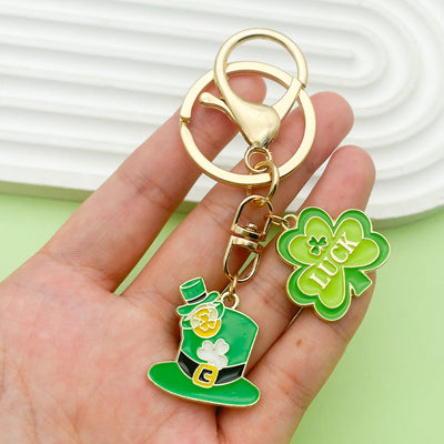 Image 1 showing a person holding up a green shamrock keychain.