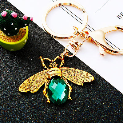 Main image 1 shows a supplied presentation of minimal jeweled bee keychains with visible attached key hardware.