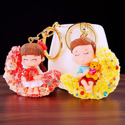 A styled front view shows the boy and girl couple keychain pair and its attached hardware.