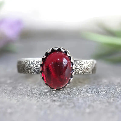 Front studio shot of scalloped bezel red cabochon engraved ring